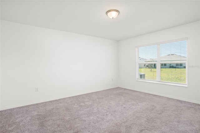 carpeted spare room featuring baseboards