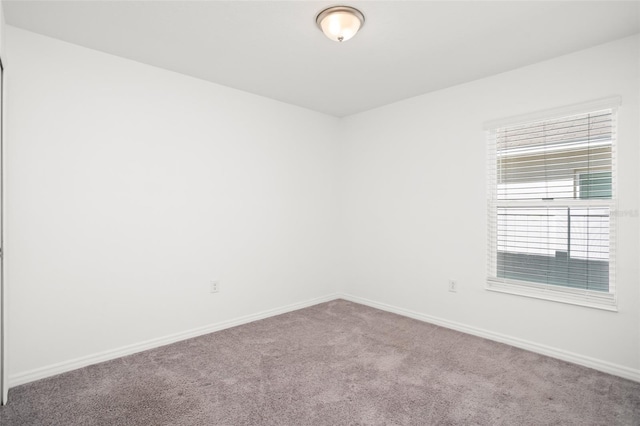 unfurnished room with carpet floors and baseboards