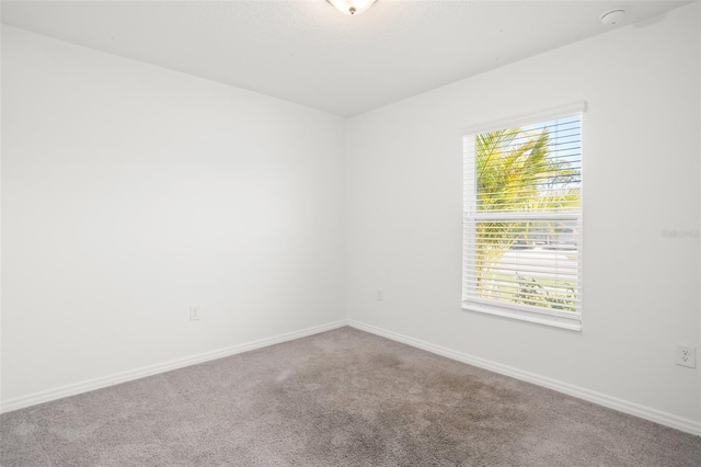 empty room featuring baseboards and carpet flooring