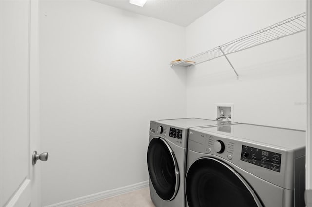 laundry room featuring washer and dryer, laundry area, baseboards, and light tile patterned floors