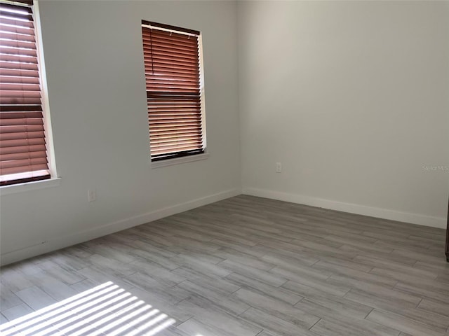 spare room featuring wood finished floors and baseboards