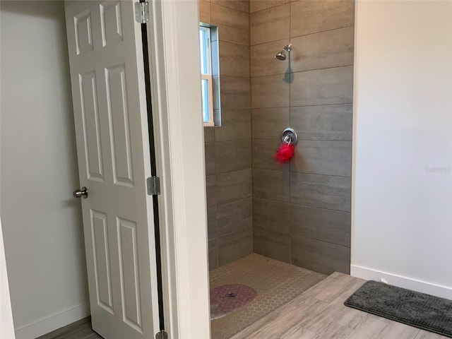 full bath featuring baseboards and a tile shower