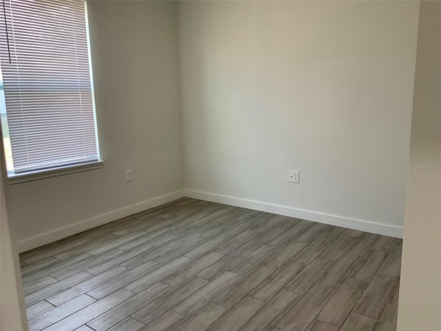 empty room with wood finished floors and baseboards