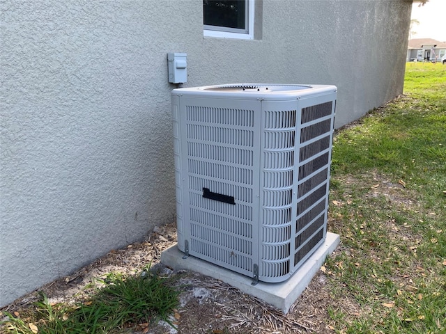 exterior details featuring stucco siding and central AC unit