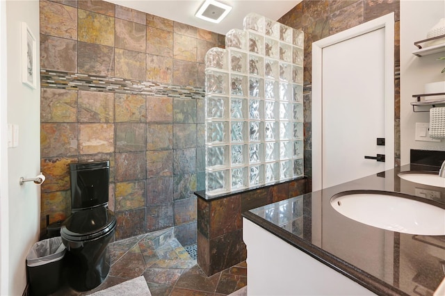 bathroom with a sink, visible vents, walk in shower, and stone tile floors