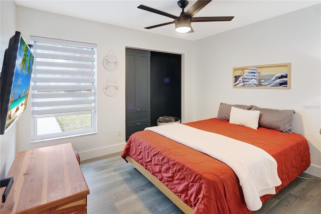 bedroom with baseboards, wood finished floors, and a ceiling fan