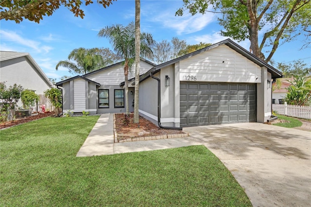 view of front of property with a front lawn, fence, a garage, and driveway