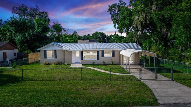 view of front of house with concrete driveway, a gate, a yard, and a fenced front yard