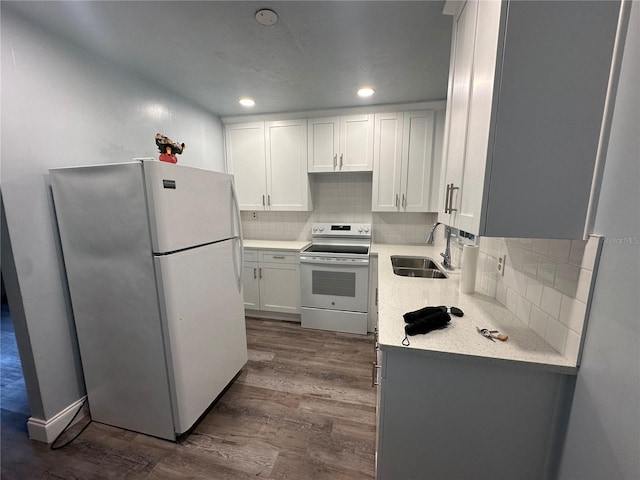 kitchen with white appliances, dark wood-style floors, white cabinets, and a sink