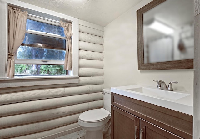 bathroom featuring log walls, toilet, and vanity