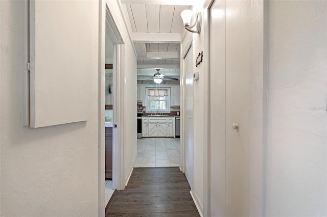 hallway featuring beamed ceiling, dark wood-style flooring, and a sink