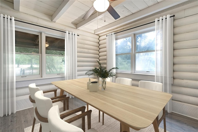 dining room with beam ceiling, wooden ceiling, wood finished floors, log walls, and a ceiling fan