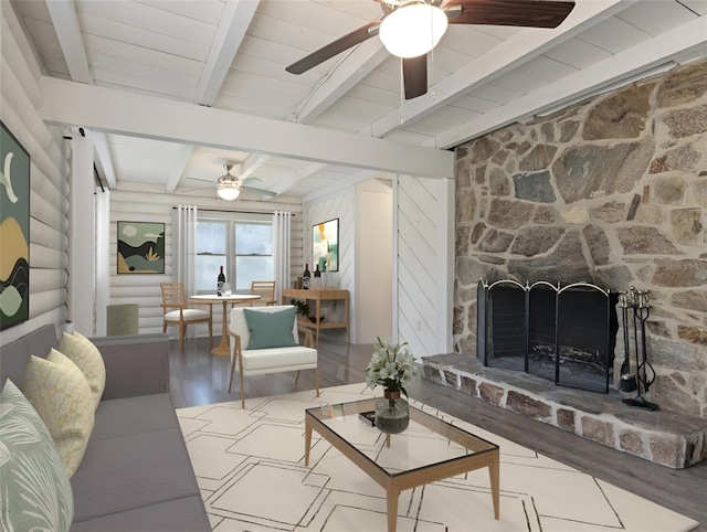 living room with beam ceiling, wood finished floors, rustic walls, a stone fireplace, and ceiling fan