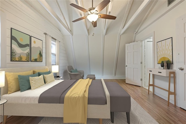 bedroom featuring lofted ceiling with beams, visible vents, wood finished floors, and a ceiling fan