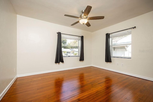 unfurnished room featuring hardwood / wood-style floors, a ceiling fan, a wealth of natural light, and baseboards