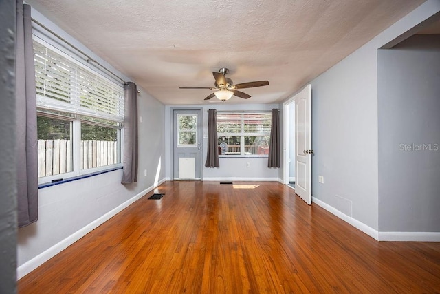 unfurnished room with baseboards, visible vents, and wood finished floors