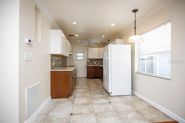 kitchen featuring ornamental molding, freestanding refrigerator, visible vents, and backsplash