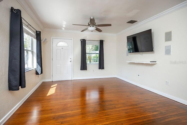 foyer entrance featuring ornamental molding, a healthy amount of sunlight, visible vents, and wood finished floors