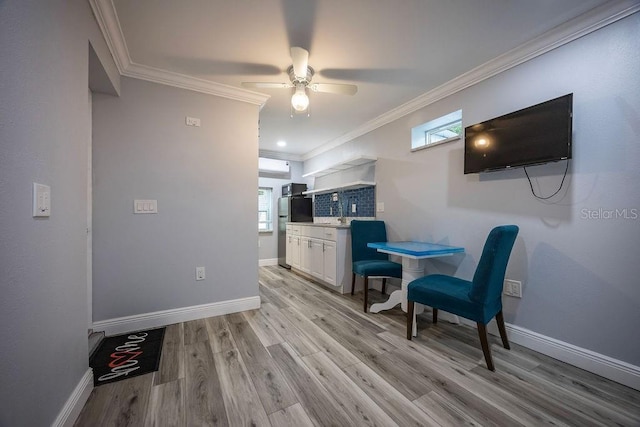 kitchen with light wood-type flooring, baseboards, and ornamental molding