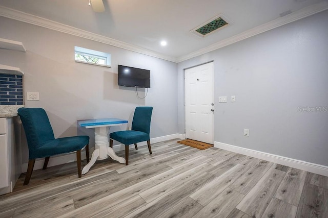 living area with visible vents, crown molding, light wood-style flooring, and baseboards