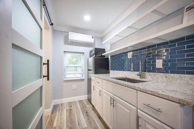 kitchen featuring a sink, ornamental molding, a wall mounted AC, decorative backsplash, and light wood finished floors