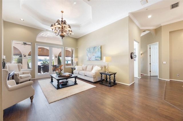 living room with visible vents, baseboards, dark wood-style flooring, and crown molding