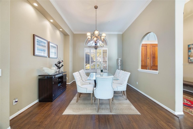 dining space with a notable chandelier, ornamental molding, baseboards, and wood finished floors