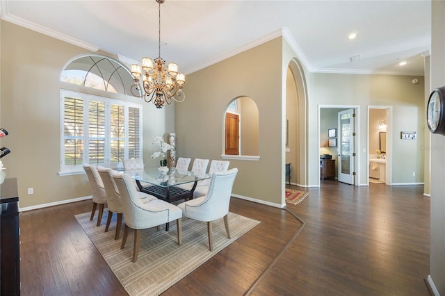 dining space featuring wood finished floors, baseboards, arched walkways, ornamental molding, and a notable chandelier