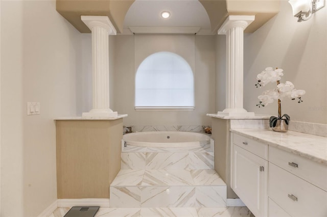 bathroom with marble finish floor, vanity, a garden tub, and decorative columns