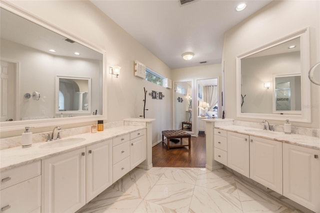 bathroom featuring two vanities, visible vents, marble finish floor, and a sink