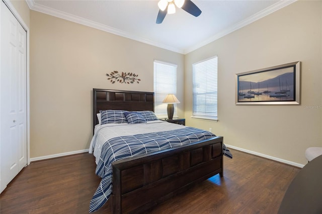 bedroom with a closet, crown molding, baseboards, and wood finished floors