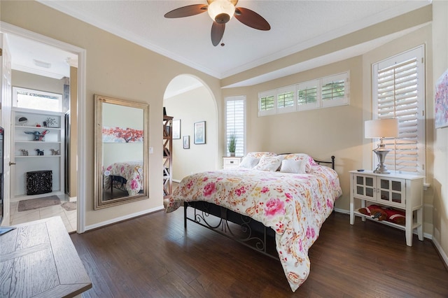 bedroom with ceiling fan, crown molding, baseboards, and wood finished floors