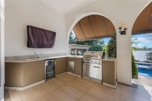 view of patio featuring wine cooler, area for grilling, and a water view