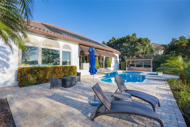 view of pool featuring a patio area and a pool with connected hot tub