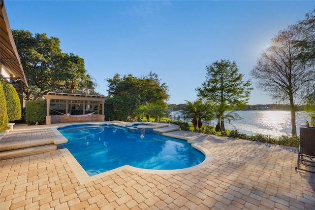 view of swimming pool featuring a patio, a water view, and a pool with connected hot tub