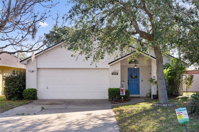 view of front of house featuring driveway, brick siding, and an attached garage