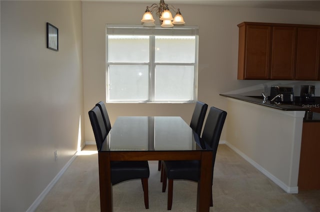 dining area featuring baseboards, an inviting chandelier, and light colored carpet