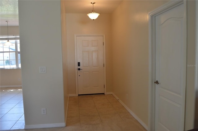 doorway to outside featuring light tile patterned floors and baseboards