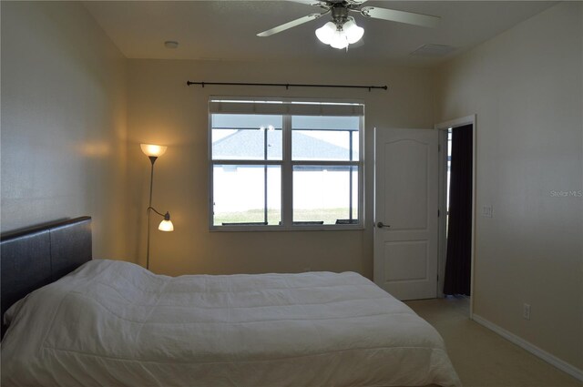 bedroom featuring light carpet, ceiling fan, and baseboards