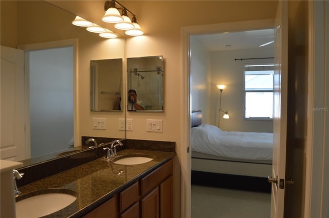 bathroom with ensuite bathroom, double vanity, and a sink