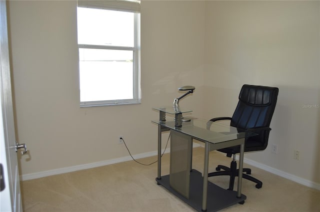 office area featuring light carpet and baseboards