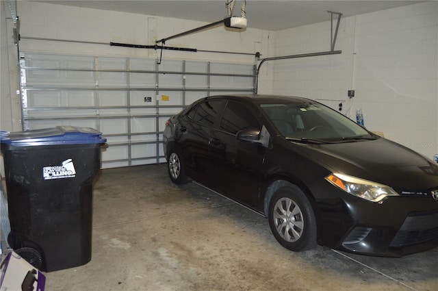 garage with concrete block wall and a garage door opener