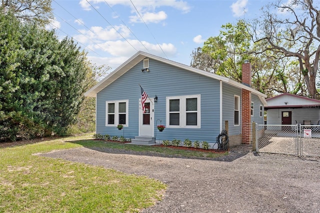 view of front of house featuring entry steps, a chimney, a gate, and fence