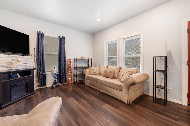 living area featuring dark wood-style floors, recessed lighting, a glass covered fireplace, and baseboards