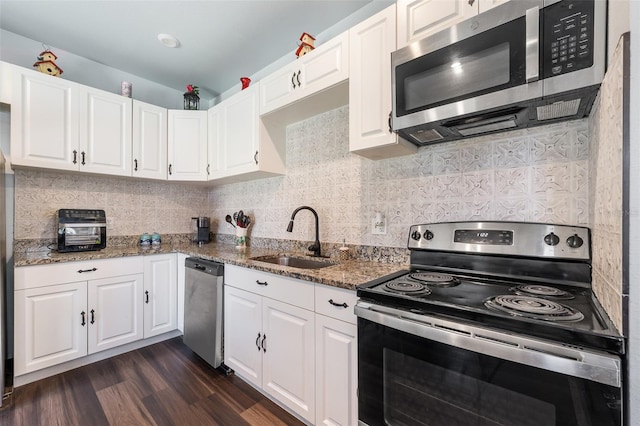 kitchen featuring decorative backsplash, dark wood-style flooring, light stone countertops, stainless steel appliances, and a sink