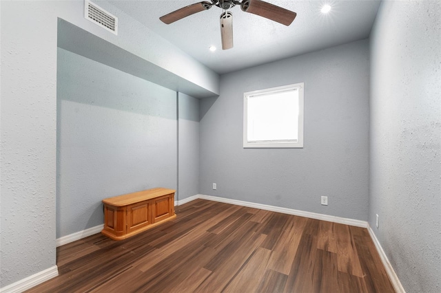 empty room with baseboards, visible vents, and dark wood-style flooring