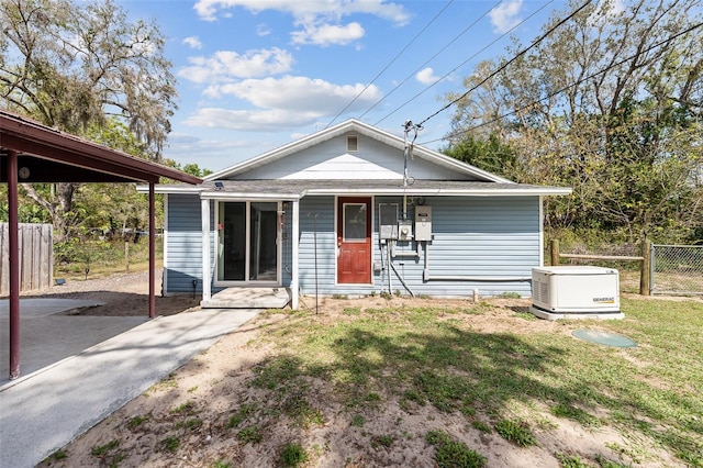 back of house with a yard, fence, driveway, and a porch