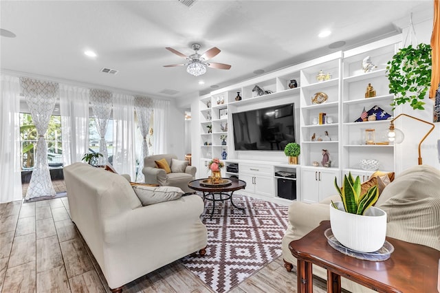 living room with light wood finished floors, visible vents, crown molding, ceiling fan, and recessed lighting