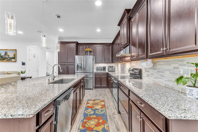 kitchen featuring a sink, under cabinet range hood, appliances with stainless steel finishes, light wood-type flooring, and backsplash