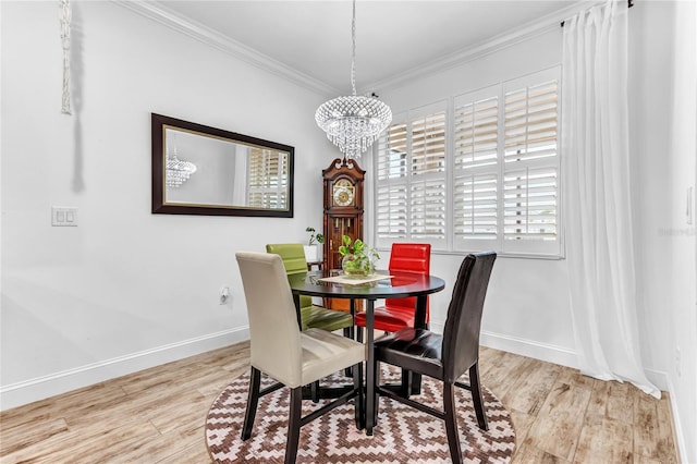 dining room featuring a chandelier, baseboards, wood finished floors, and crown molding